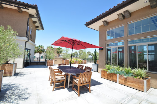 A bright and inviting outdoor dining area featuring a large red umbrella, perfect for enjoying meals in the sun.