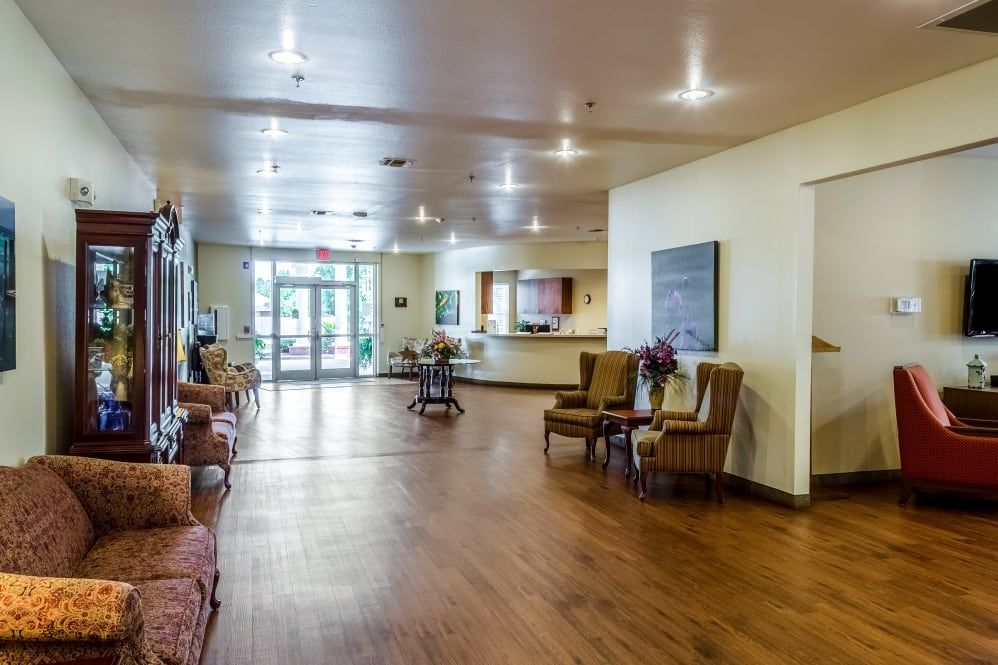A spacious lobby with wooden flooring and comfortable seating areas.