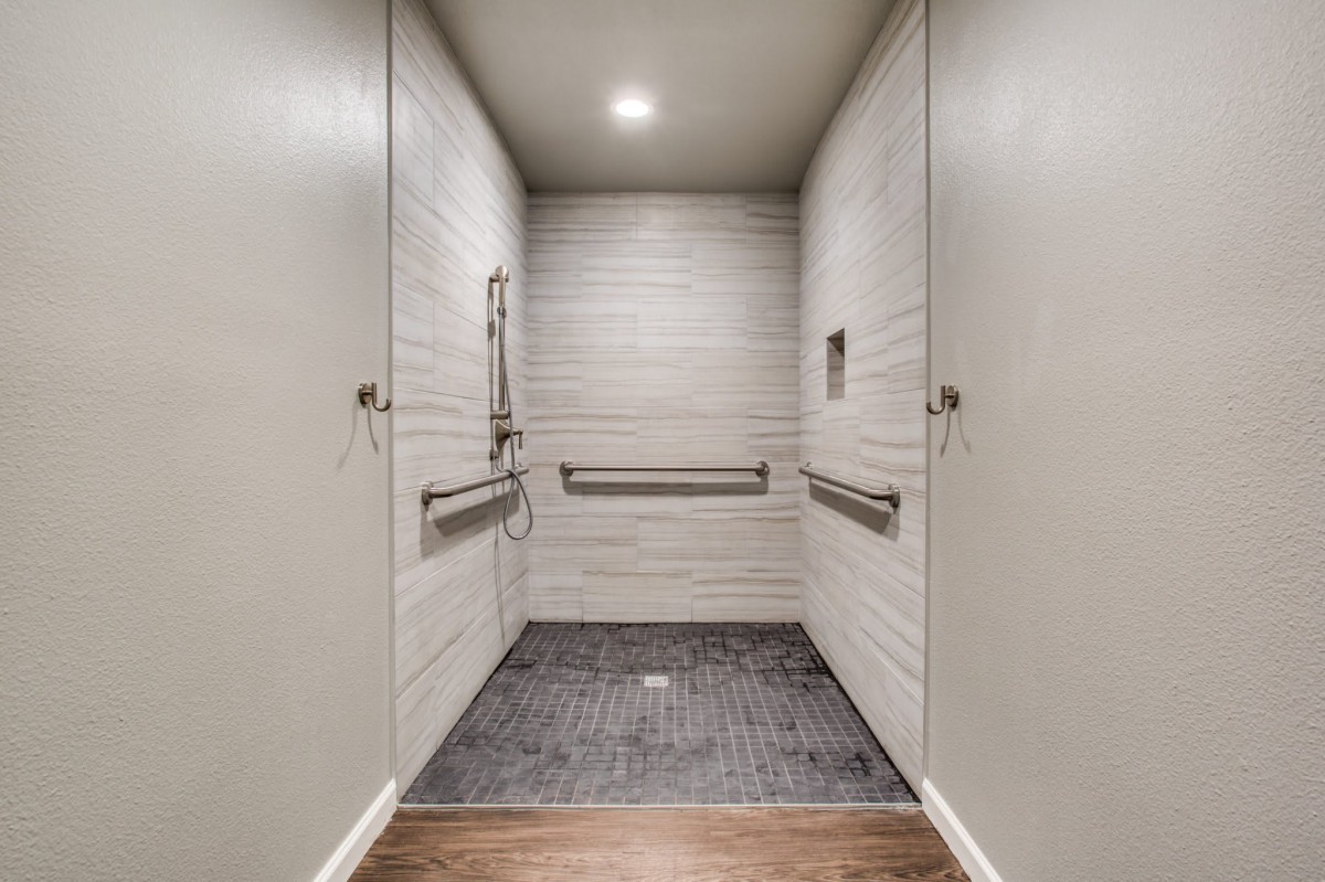 Interior view of a modern elevator with metal railings and neutral colors.