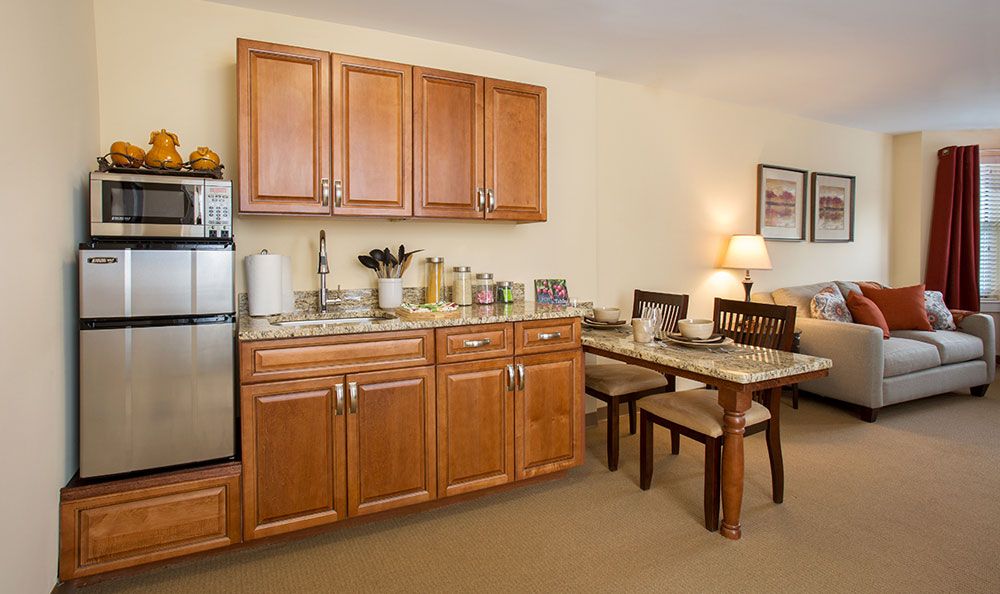 A cozy kitchen and dining area with wooden cabinets, a table set for dining, and various appliances.