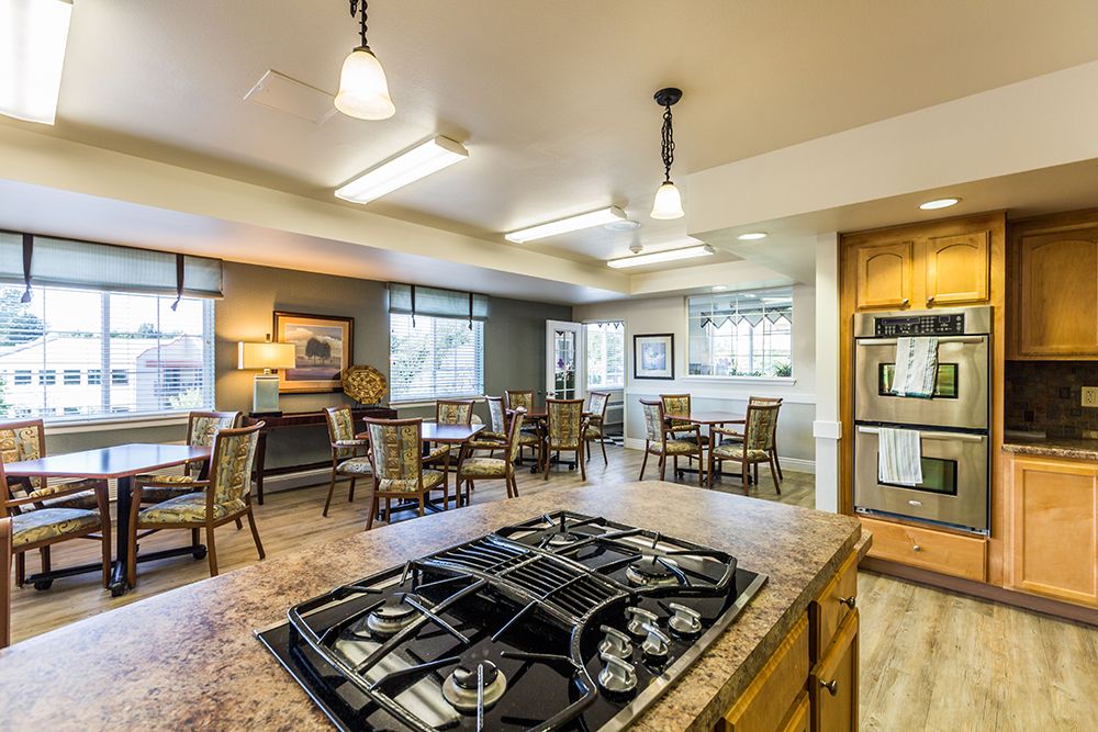 A well-lit kitchen with a dining area, featuring modern appliances and comfortable seating.