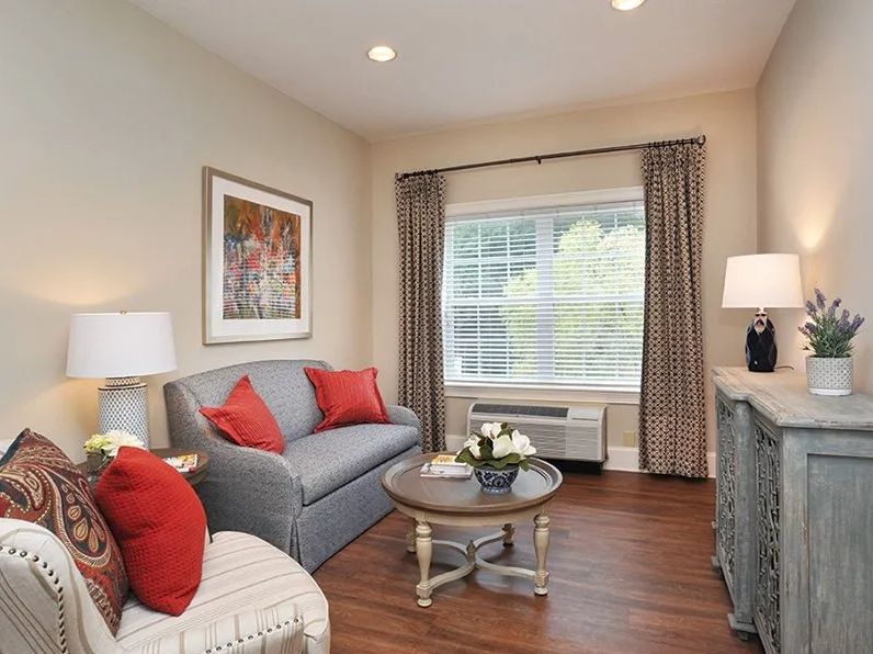 Cozy living room with a gray sofa, red cushions, and elegant decor.