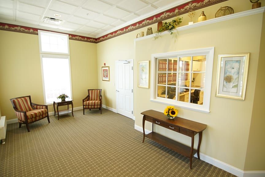 A cozy waiting room with chairs, a table, and decorative elements.