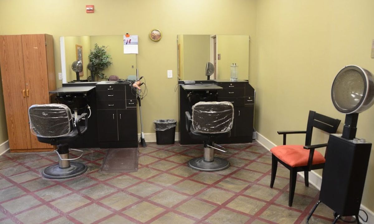 An interior view of a salon with chairs and mirrors.