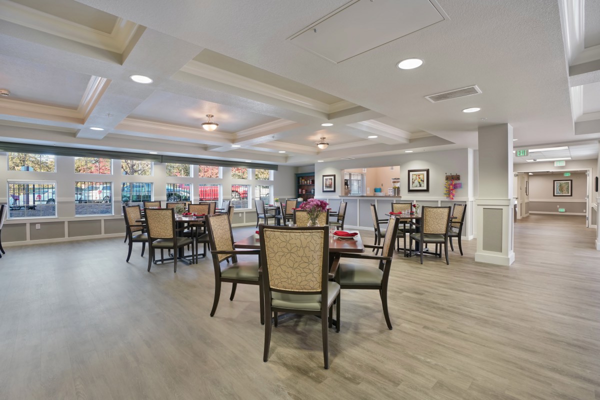 A modern dining area with neatly arranged tables and chairs, featuring tasteful decor and ambient lighting.
