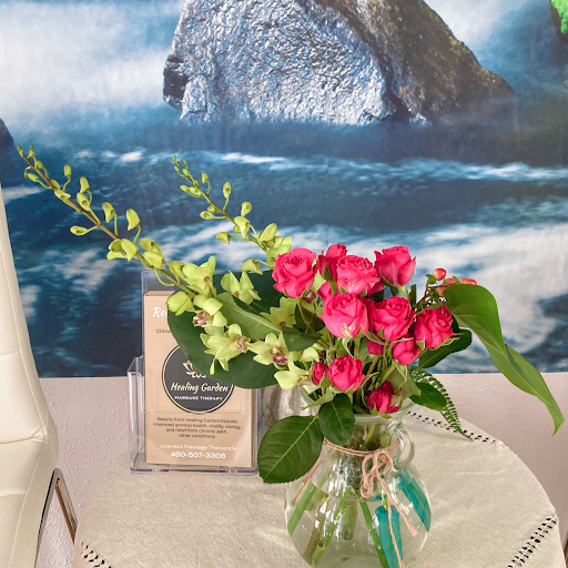 A beautiful floral arrangement featuring vibrant pink roses and delicate greenery, set against a serene ocean backdrop.
