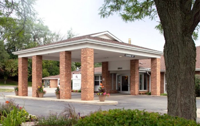 A building entrance with brick columns and a covered driveway.