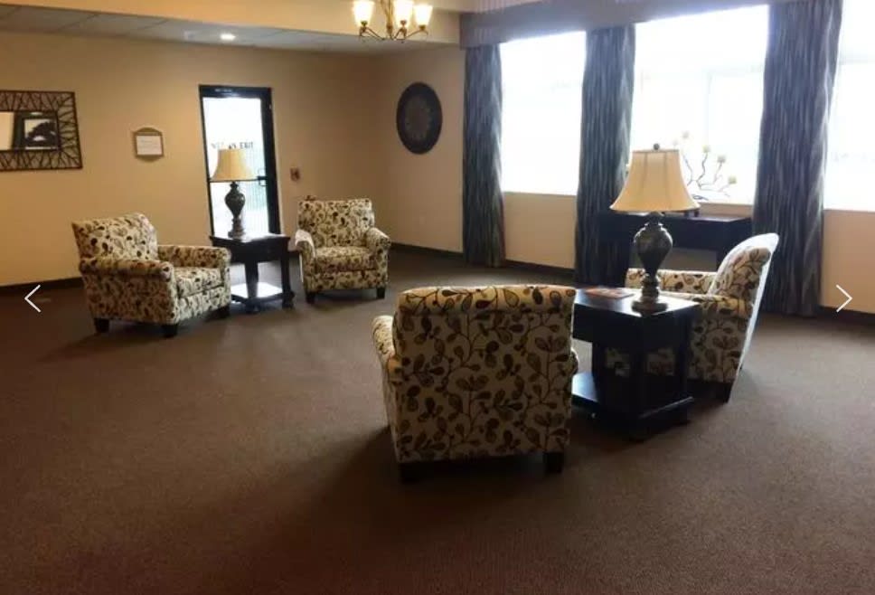 A cozy lobby with patterned chairs and lamps.