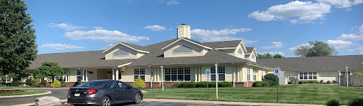 A sunny day view of a charming residential building with well-maintained landscaping.