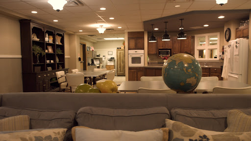 A spacious and inviting living area combined with a kitchen, featuring modern furnishings and a decorative globe.