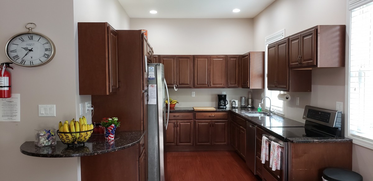 A modern kitchen with wooden cabinets and stainless steel appliances.