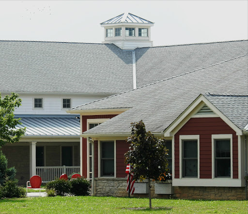 A charming house with a unique roof design and well-kept yard.