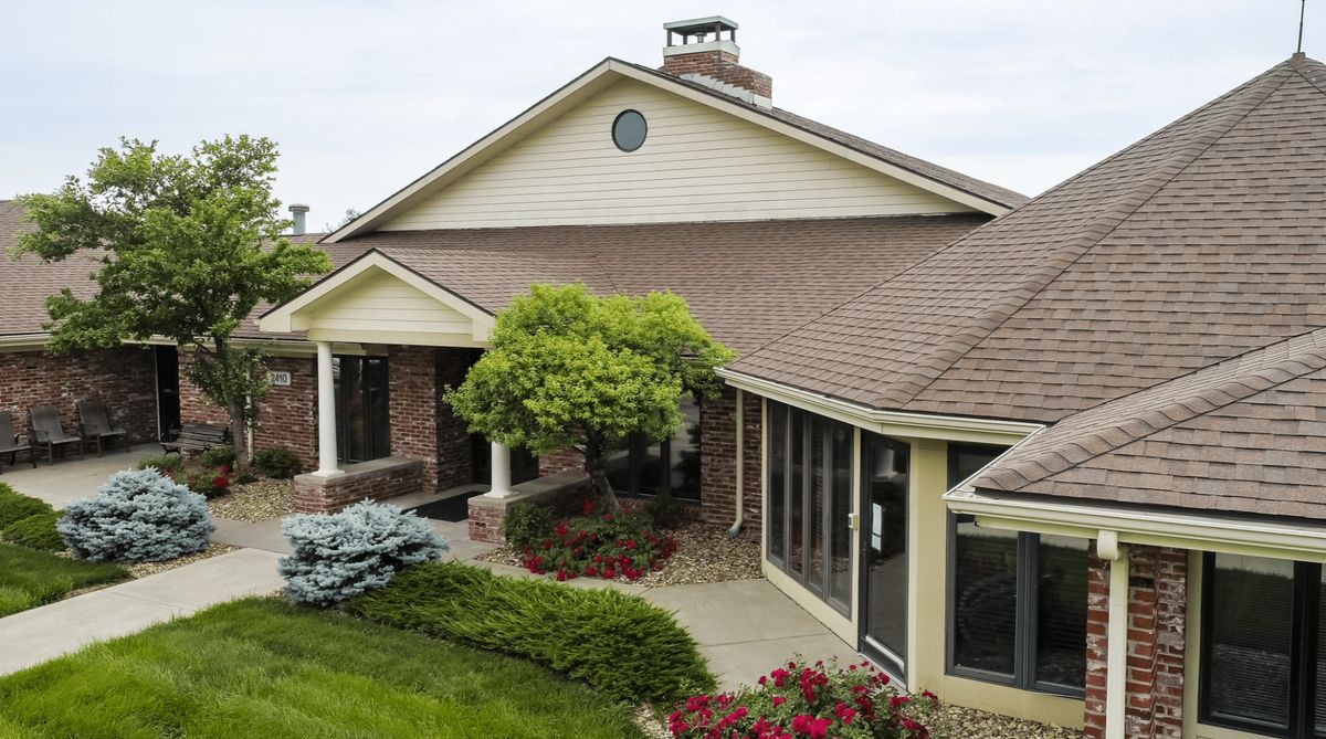 A suburban house with a well-maintained garden and brick facade.