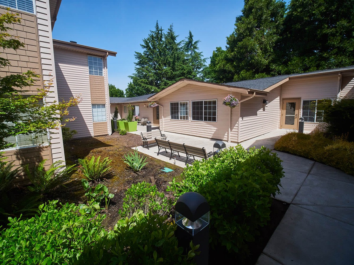 A view of a residential property with a landscaped garden and outdoor seating.