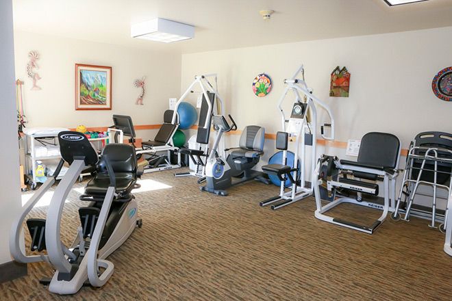 A well-equipped indoor gym with various exercise machines.