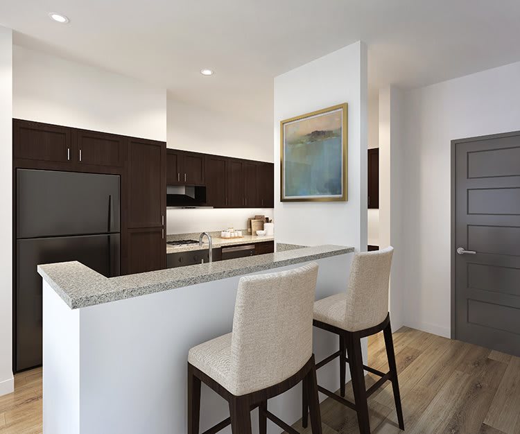 A modern kitchen featuring a sleek countertop with bar stools and contemporary appliances.