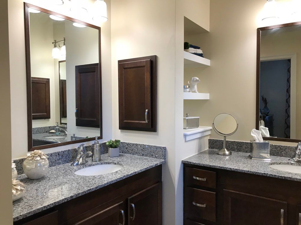Modern bathroom with granite countertops and ample storage.