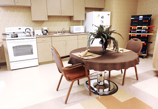 A cozy kitchen area featuring a round table, comfortable chairs, and modern appliances.