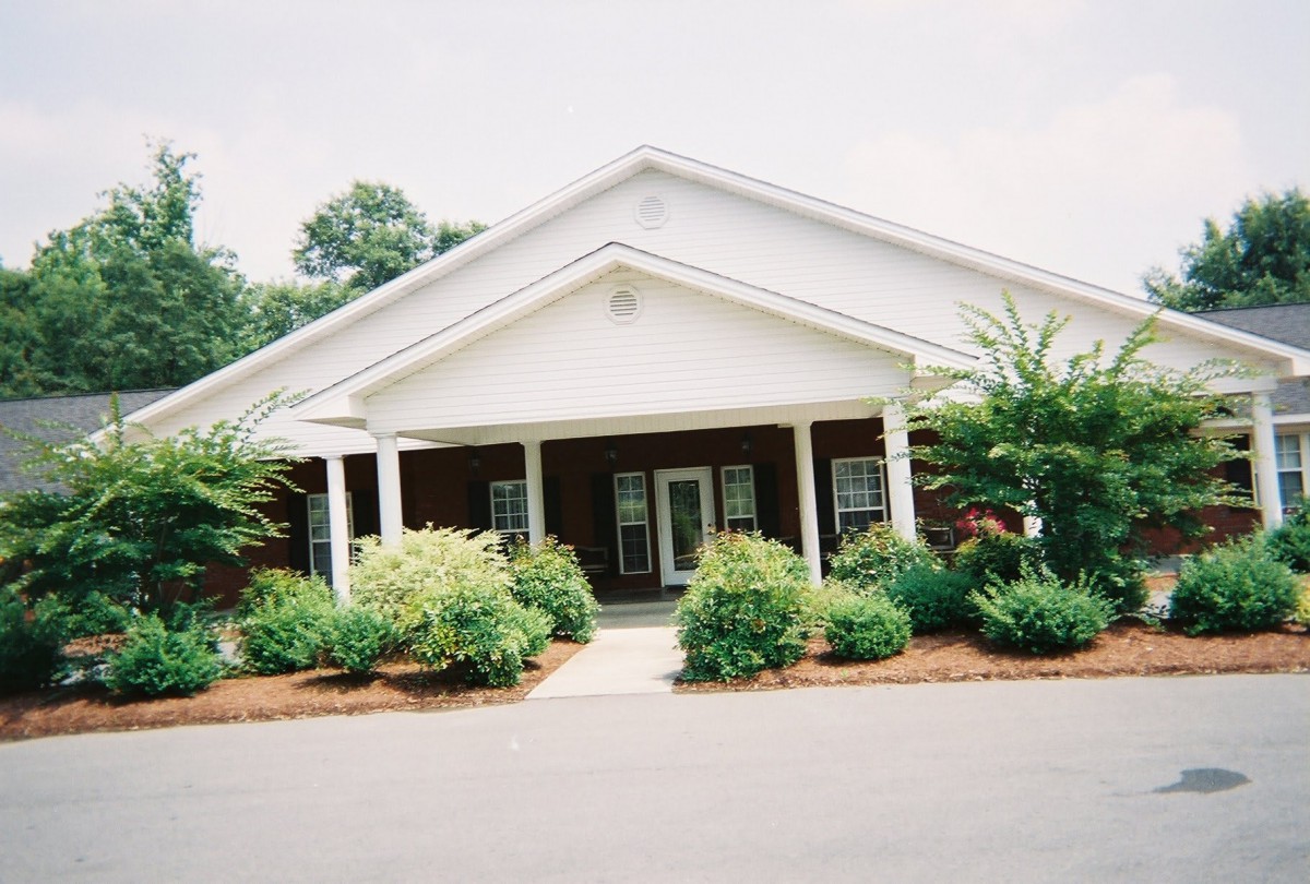 A well-landscaped building entrance with a covered walkway.