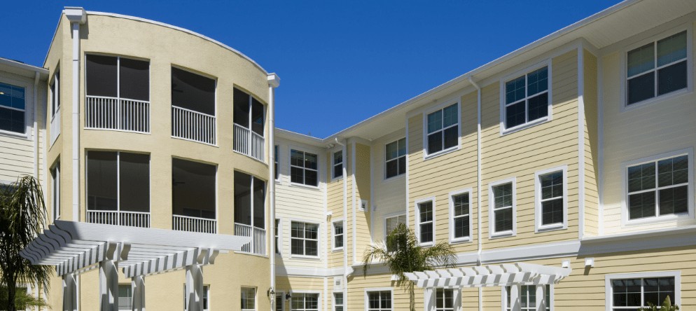 A modern residential apartment building with multiple windows under a clear blue sky.