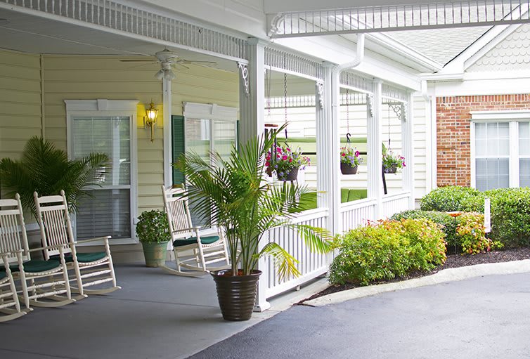 A cozy porch with rocking chairs and potted plants.