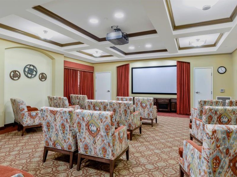A stylish theater room with decorative chairs and a large projection screen.