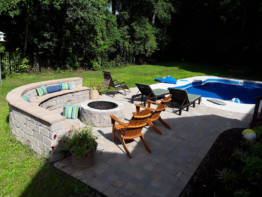 A beautiful outdoor space featuring a swimming pool, a cozy fire pit area, and comfortable seating, perfect for relaxation and entertaining.