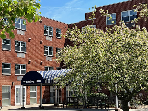 A modern brick building with a welcoming entrance and lush greenery.