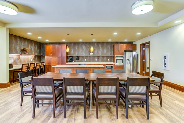 A modern kitchen with an open dining area, featuring wooden furniture and an island countertop.