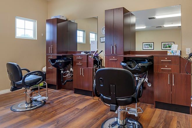 An interior view of a modern hair salon with chairs and mirrors.