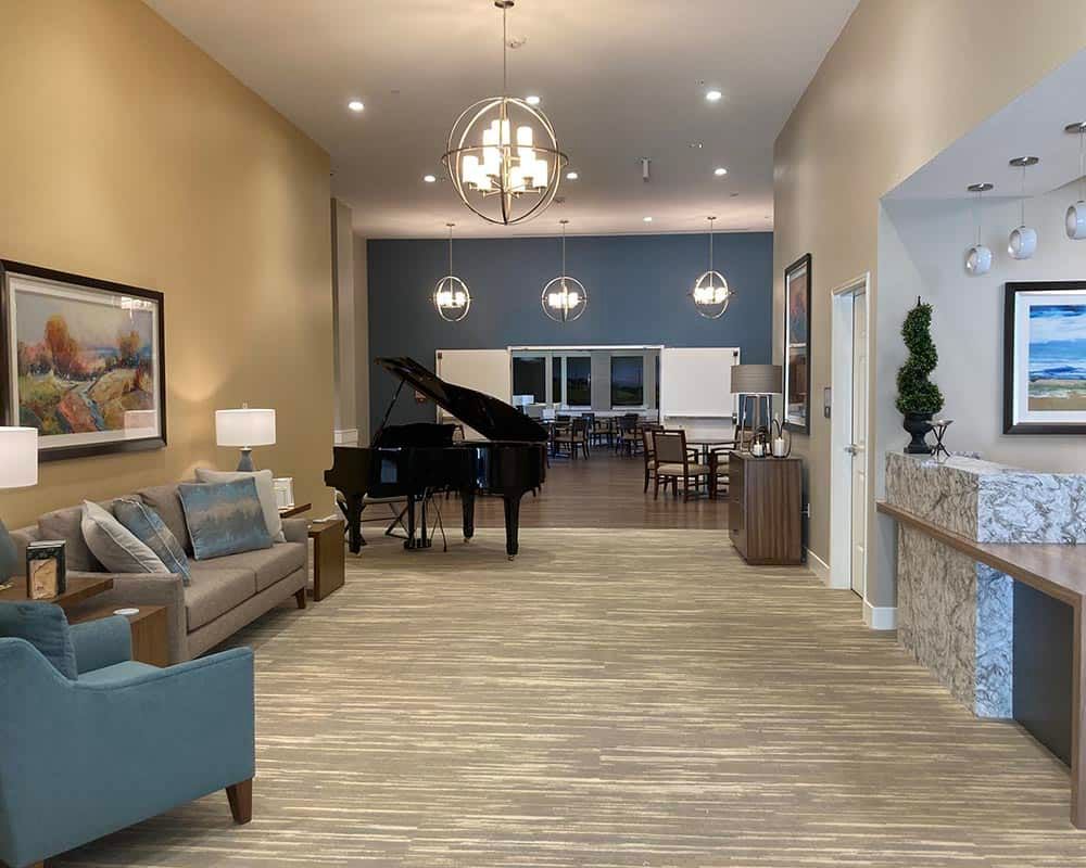 A modern lobby with a grand piano and comfortable seating area.