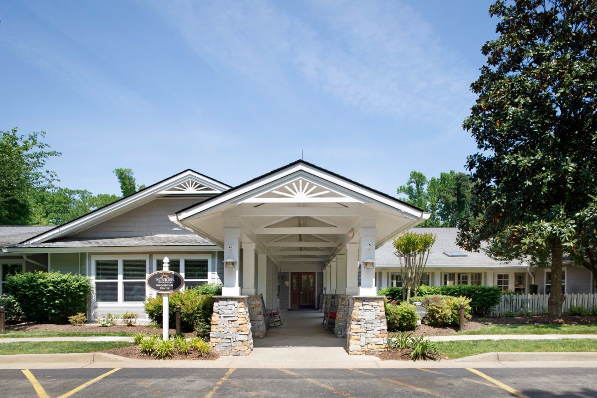 The image shows the entrance to a single-story building with well-maintained landscaping.
