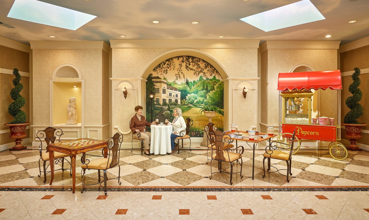 Two people sitting at a table in a cozy cafe with decorative murals on the walls.