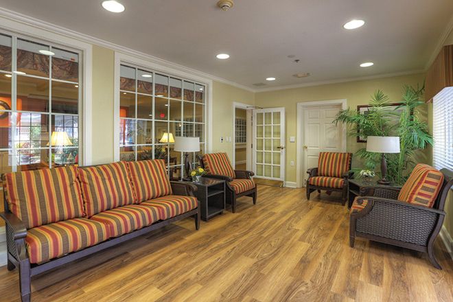 A cozy lobby with striped upholstered seating and wood flooring.