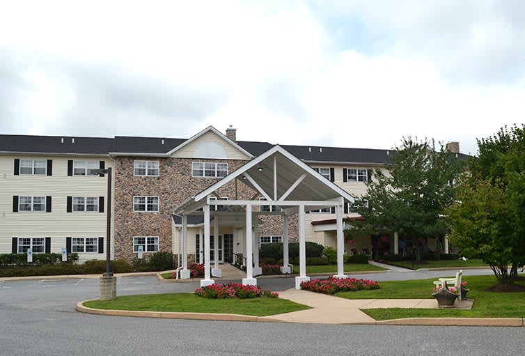 A residential building with a covered entrance and well-maintained landscaping.