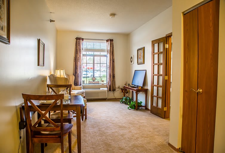 A cozy living room with wooden furniture and a large window.