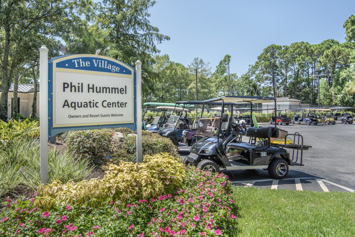 Outdoor view of Phil Hummel Aquatic Center with golf carts parked nearby.