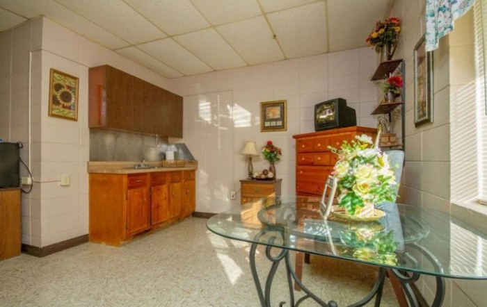 A cozy living space with a wooden cabinet, glass table, and decorative elements.