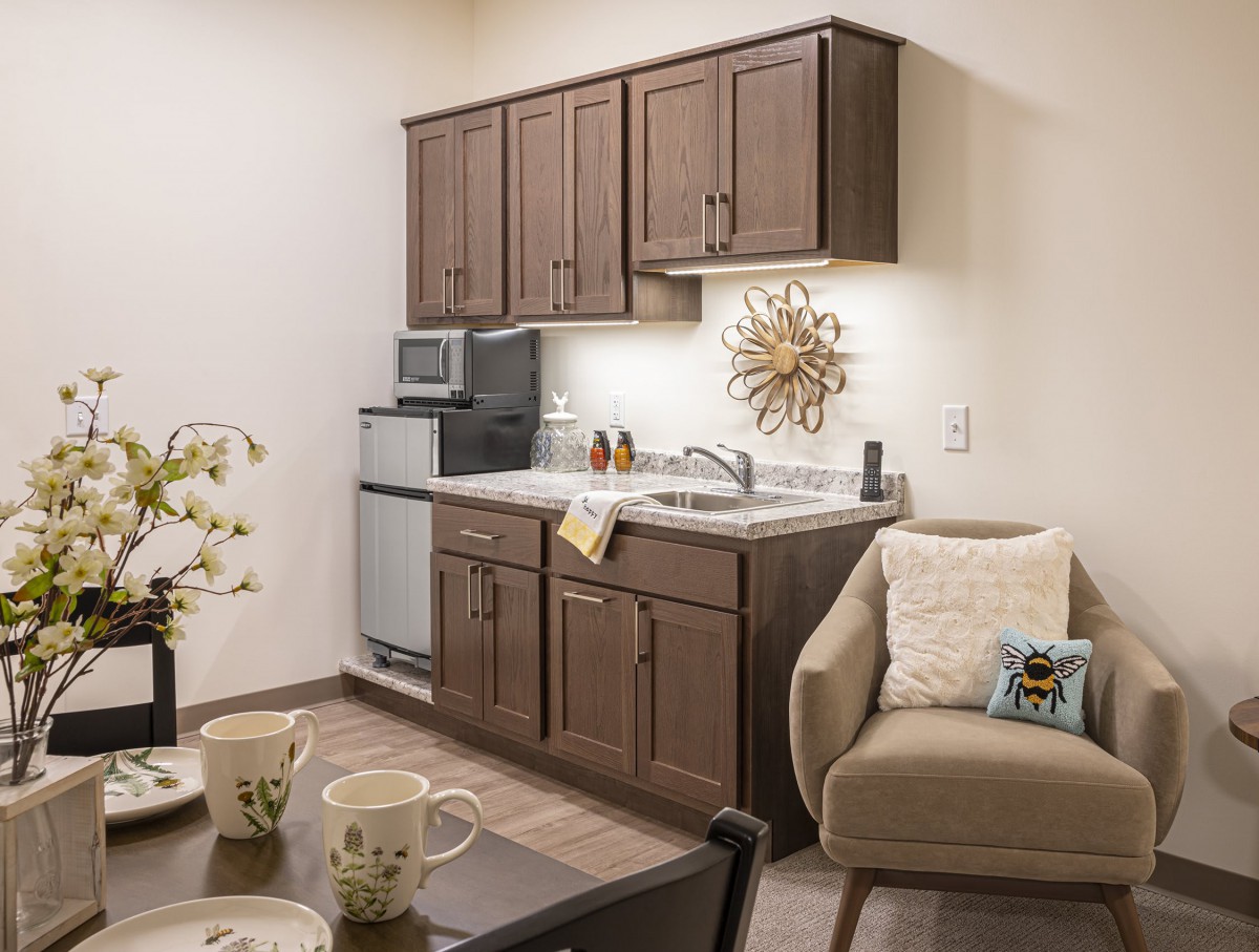A cozy kitchen and living area featuring wooden cabinets, modern appliances, and comfortable seating.