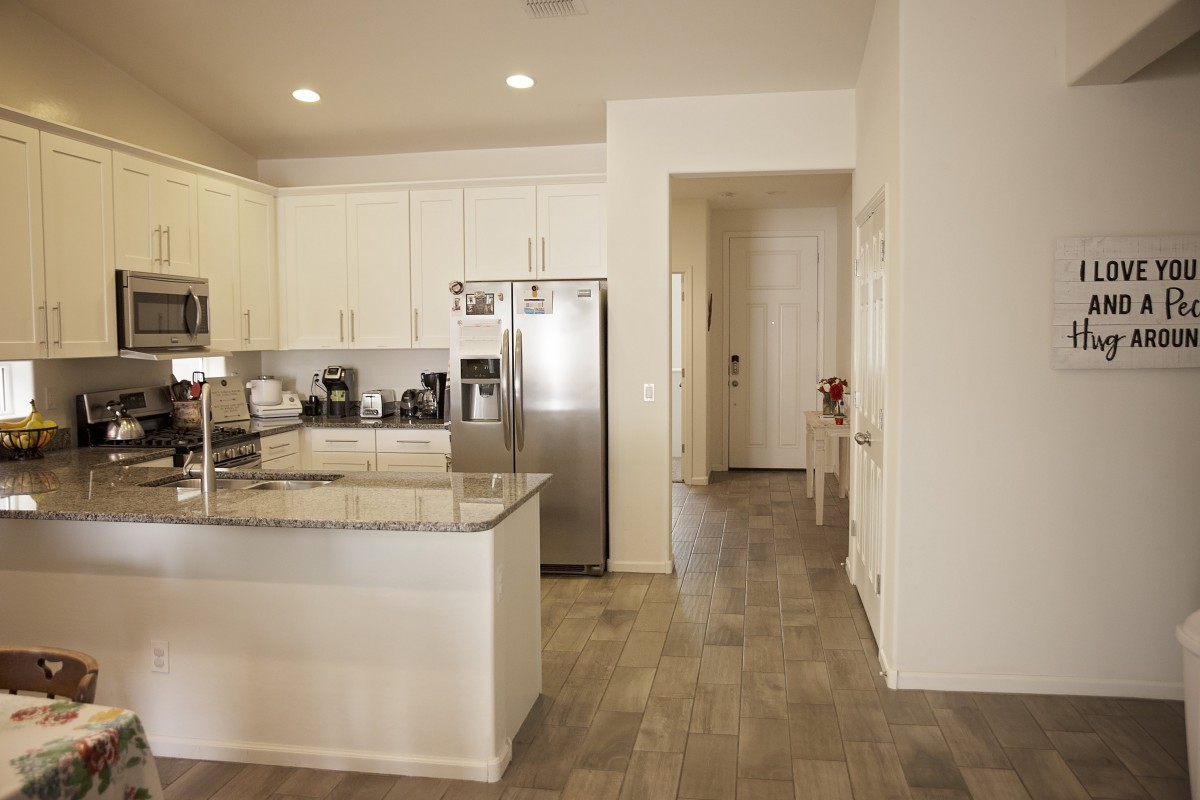 A modern kitchen interior with stainless steel appliances and white cabinetry.