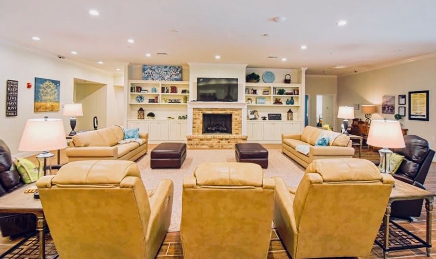 A spacious and cozy living room with comfortable seating, a fireplace, and a television.