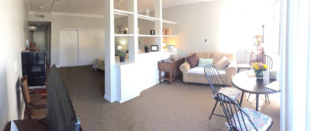A cozy living room with a sofa and open shelving, complemented by warm lighting.