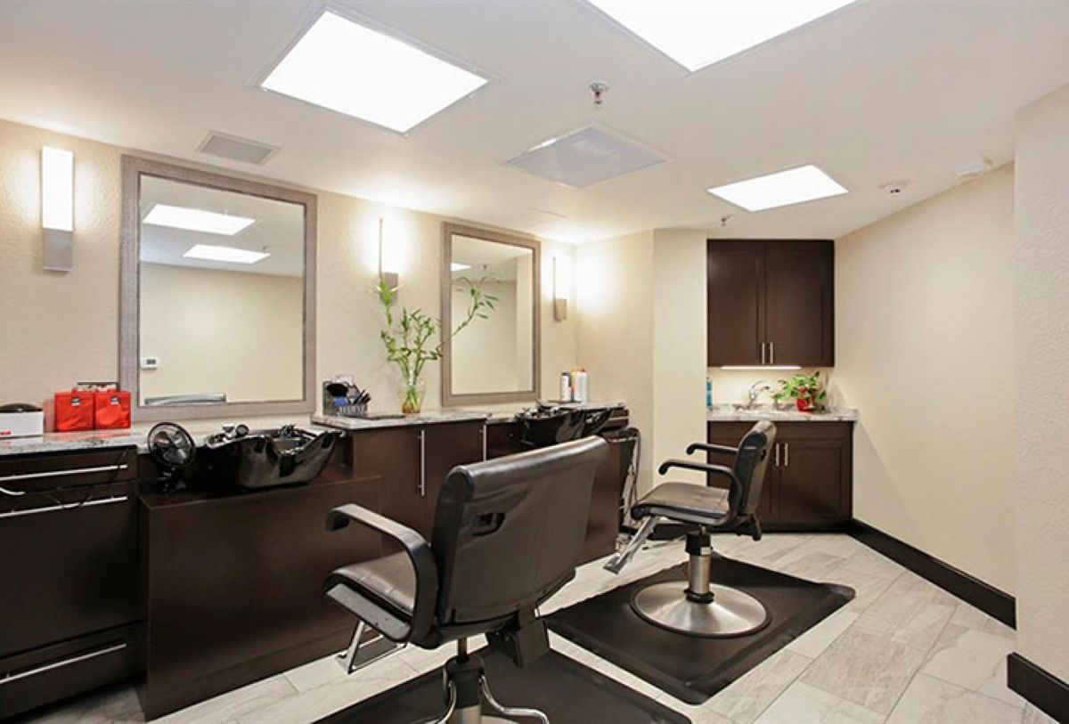 A modern hair salon with stylish chairs and large mirrors.