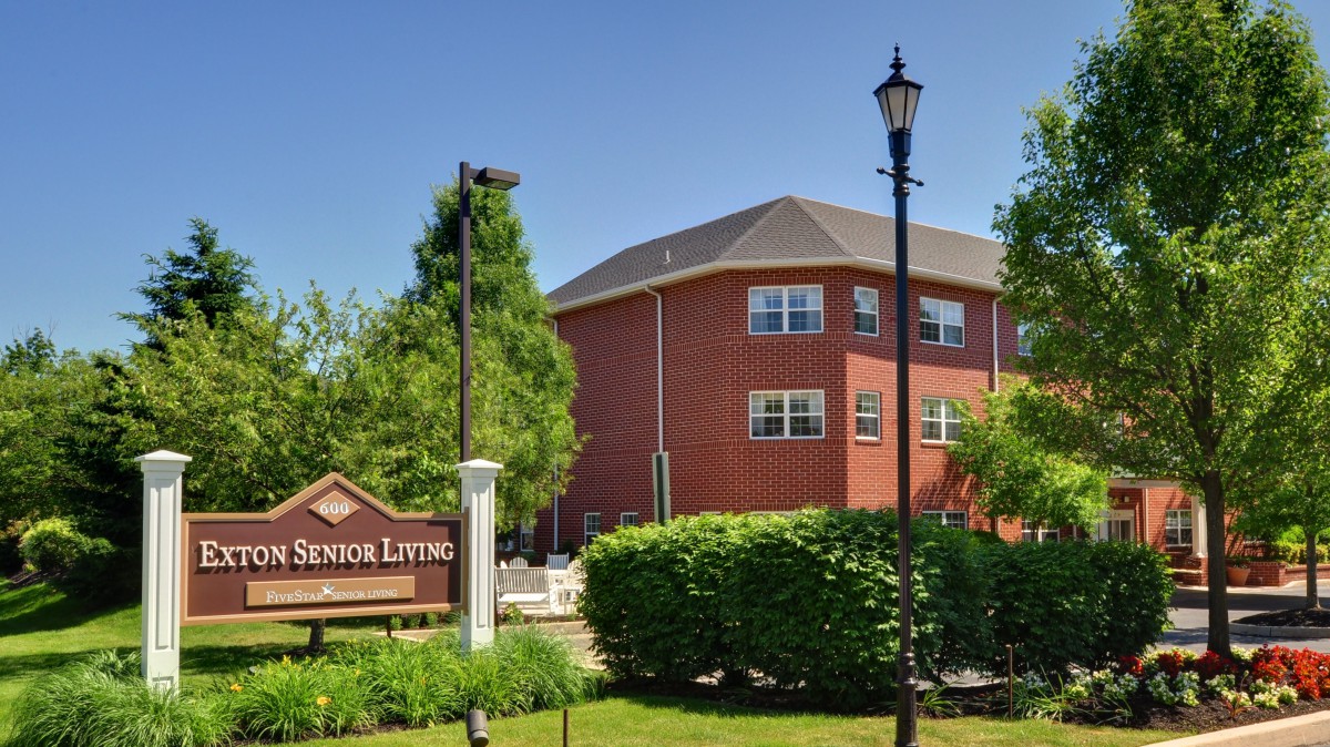A senior living facility with well-maintained landscaping and a brick exterior.