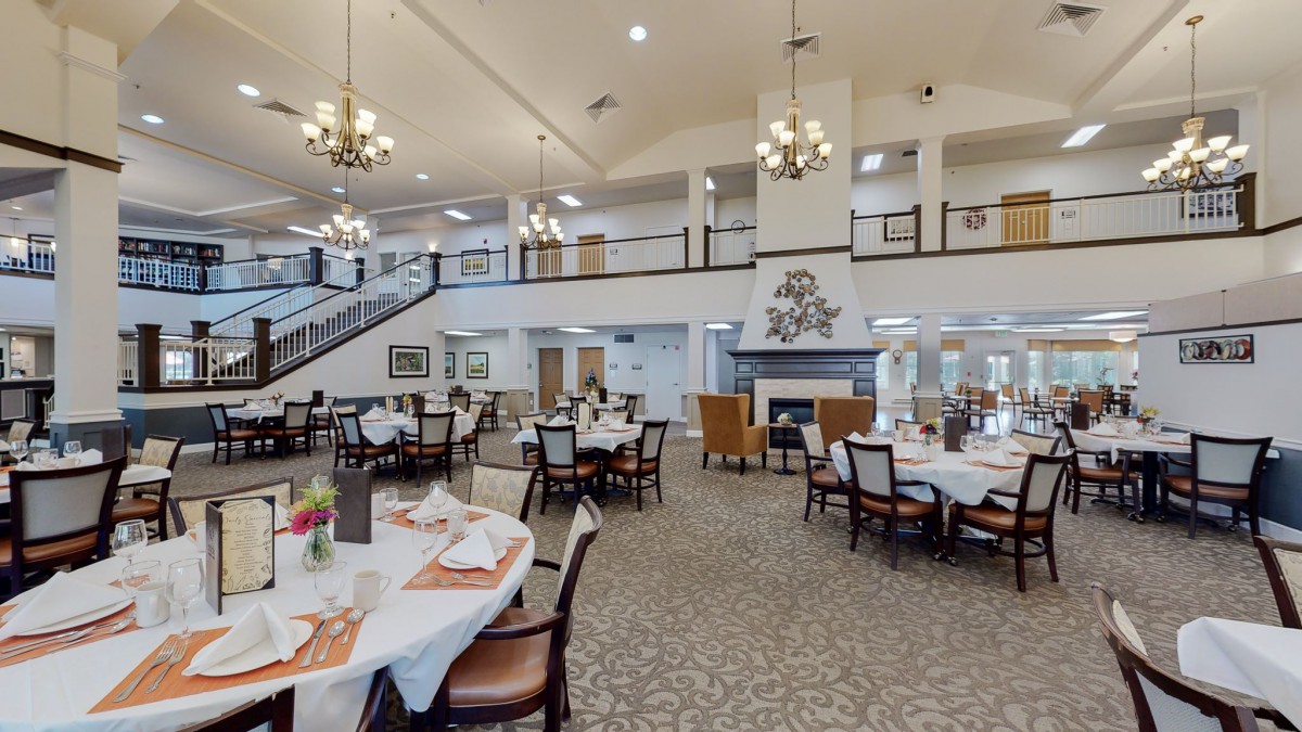 Spacious dining area with elegant chandeliers and neatly arranged tables.