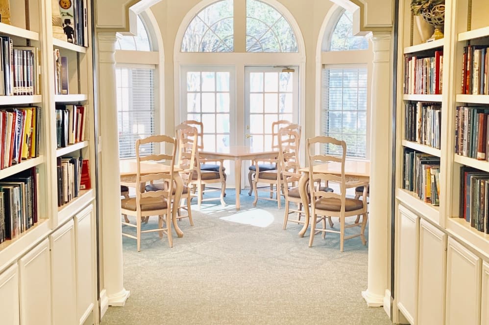 A bright dining area with arched windows letting in natural light, featuring a table and several chairs.