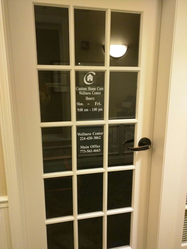 A glass door with office hours displayed in white text.