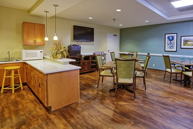 A modern kitchen and dining area with wooden floors and cozy furnishings.
