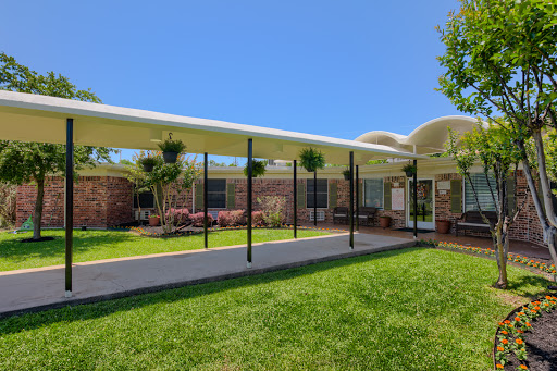 A modern outdoor patio area with vibrant green grass and clear blue skies.