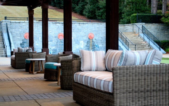 Cozy outdoor wicker furniture on a patio with striped cushions, perfect for relaxation.